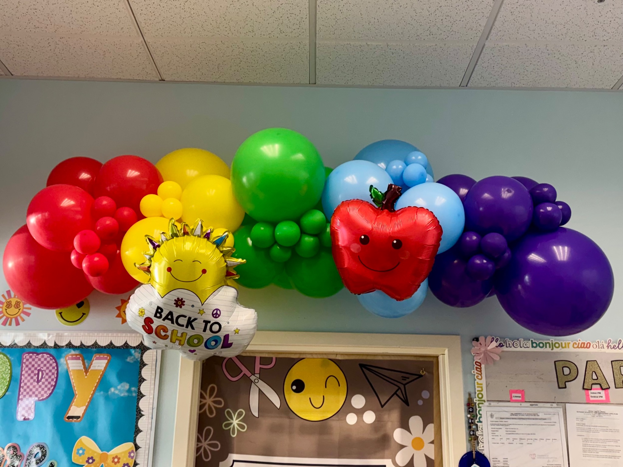 Rainbow back-to-school balloon garland with smiling school-themed balloons