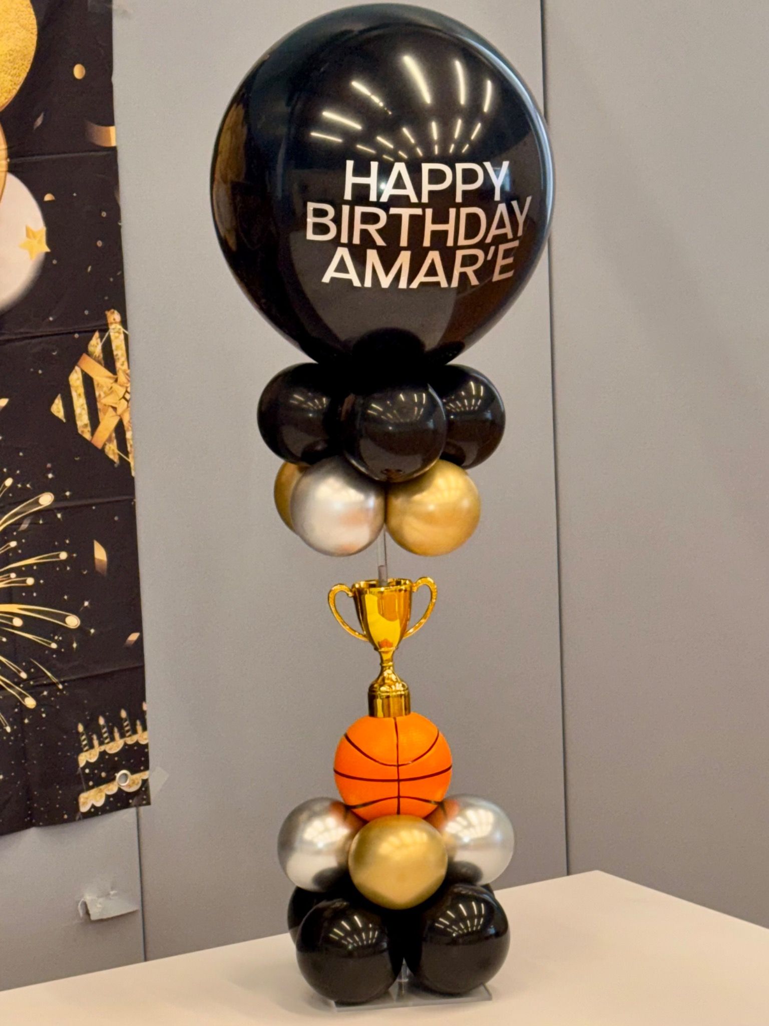 Black, gold, and silver basketball birthday balloon stack with trophy detail