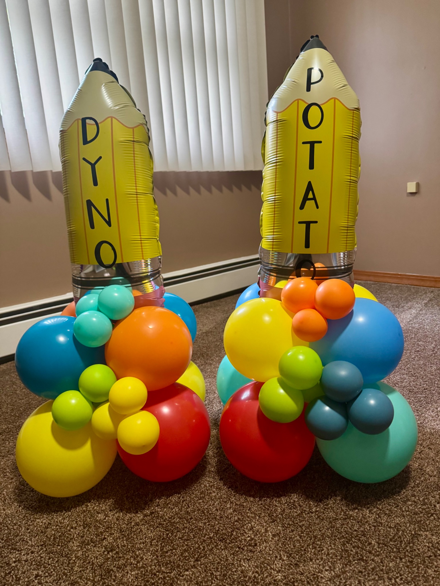 Pair of personalized yellow pencil balloon columns with colorful bases
